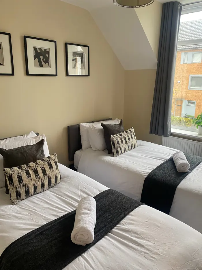 Twin bedroom made up with fresh linen and towels for guests
