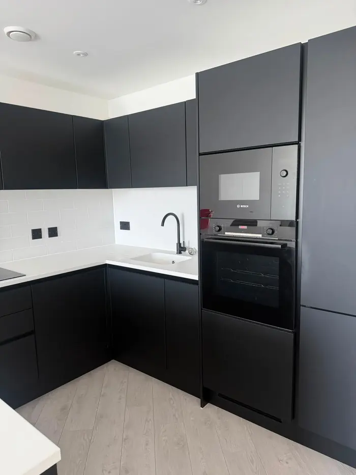 Dark modern kitchen with built-in oven, cleaned for the landlord