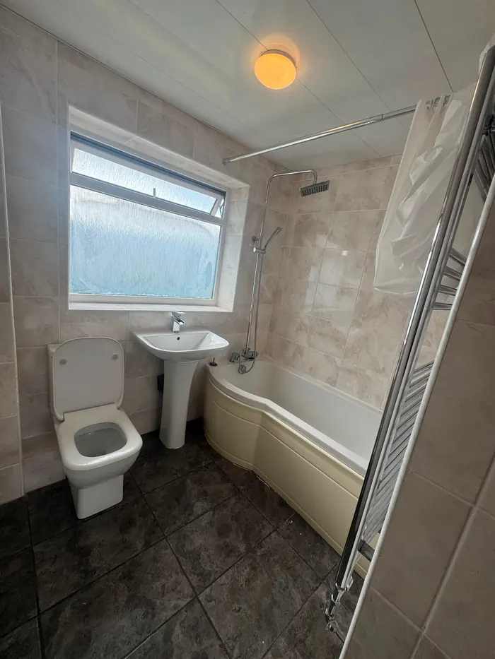 Bathroom with bath and towel rail cleaned for move-out