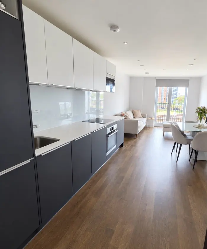 Long fitted kitchen and living area, gleaming after a clean