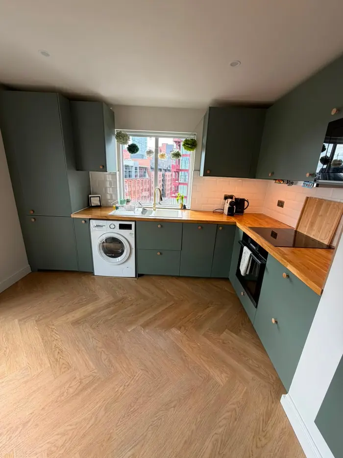 Green fitted kitchen with herringbone floor, cleaned and reset