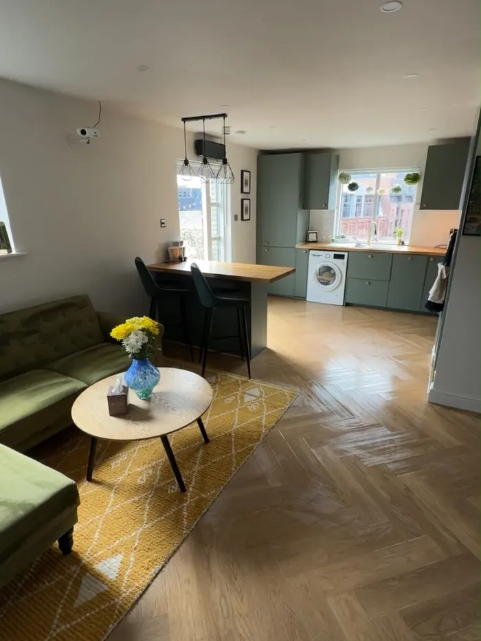 Open-plan short-let living room reset after a party